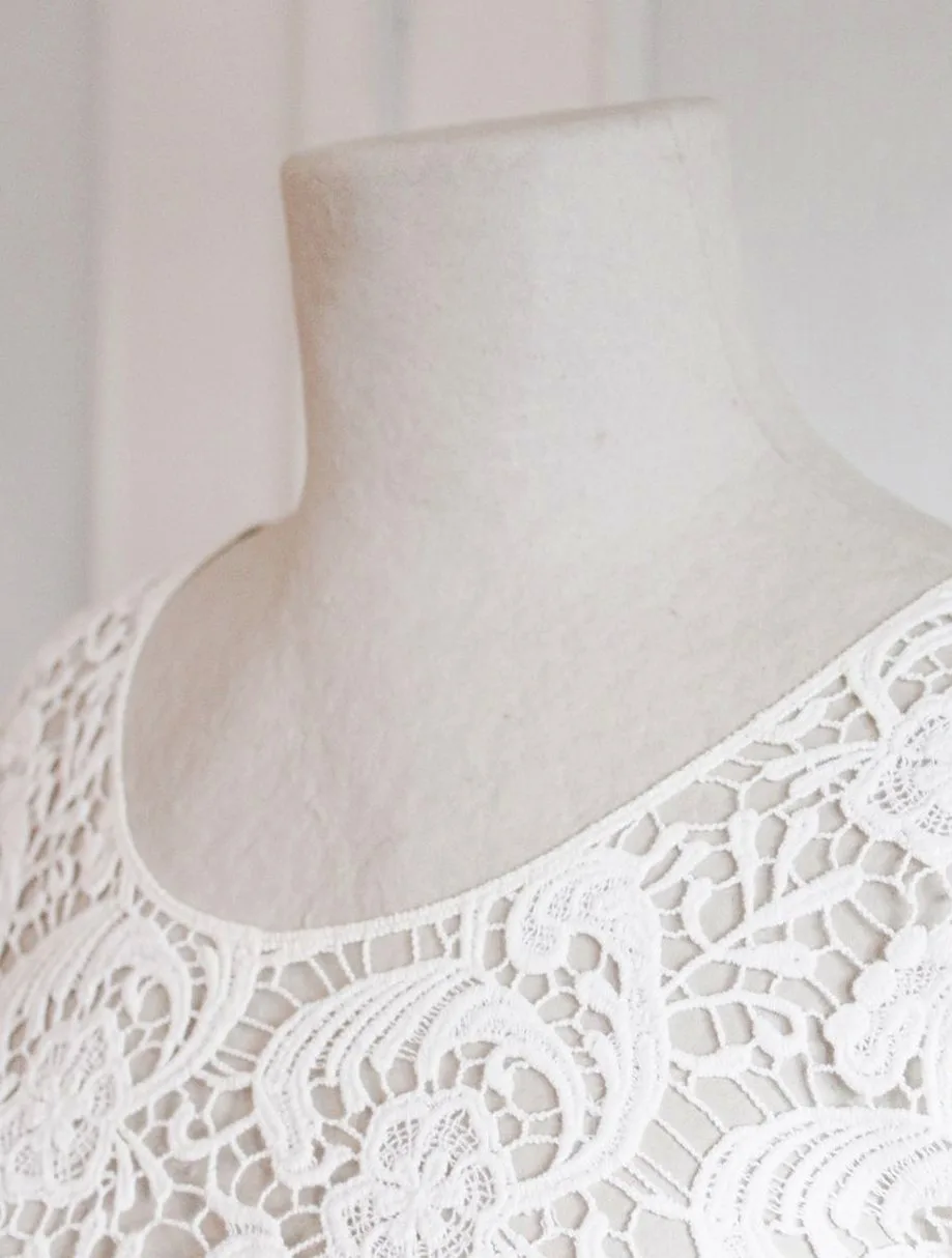 Ivory guipure lace trim on a dress form, the lace family used for garter belts